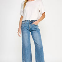 Model showcasing Tummy Control High Rise Crop Wide W/ Released Hem jeans with a relaxed fit and released hem.