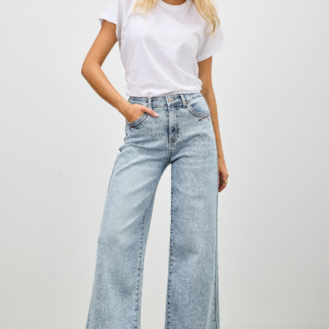 Model showcasing High Rise Wide Leg jeans paired with a casual white t-shirt in a relaxed setting.
