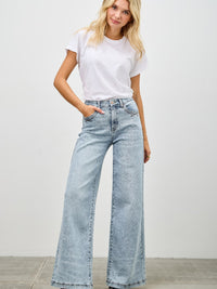 Model showcasing High Rise Wide Leg jeans paired with a casual white t-shirt in a relaxed setting.