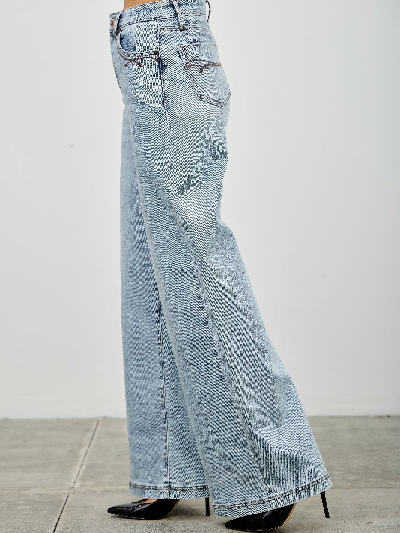 High Rise Wide Leg jeans shown in light wash, featuring a flattering wide leg design and high-waisted fit.