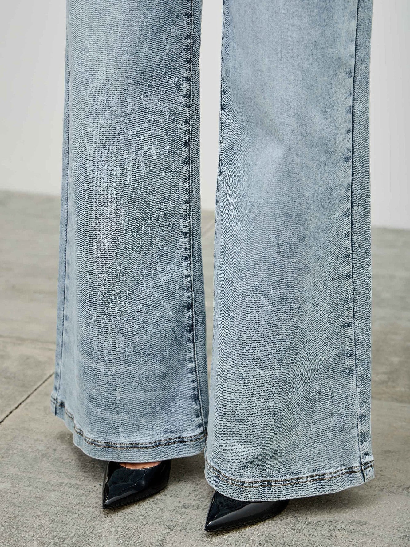 High Rise Wide Leg jeans featuring a wide leg cut and high-rise waist, paired with stylish black pointed heels.
