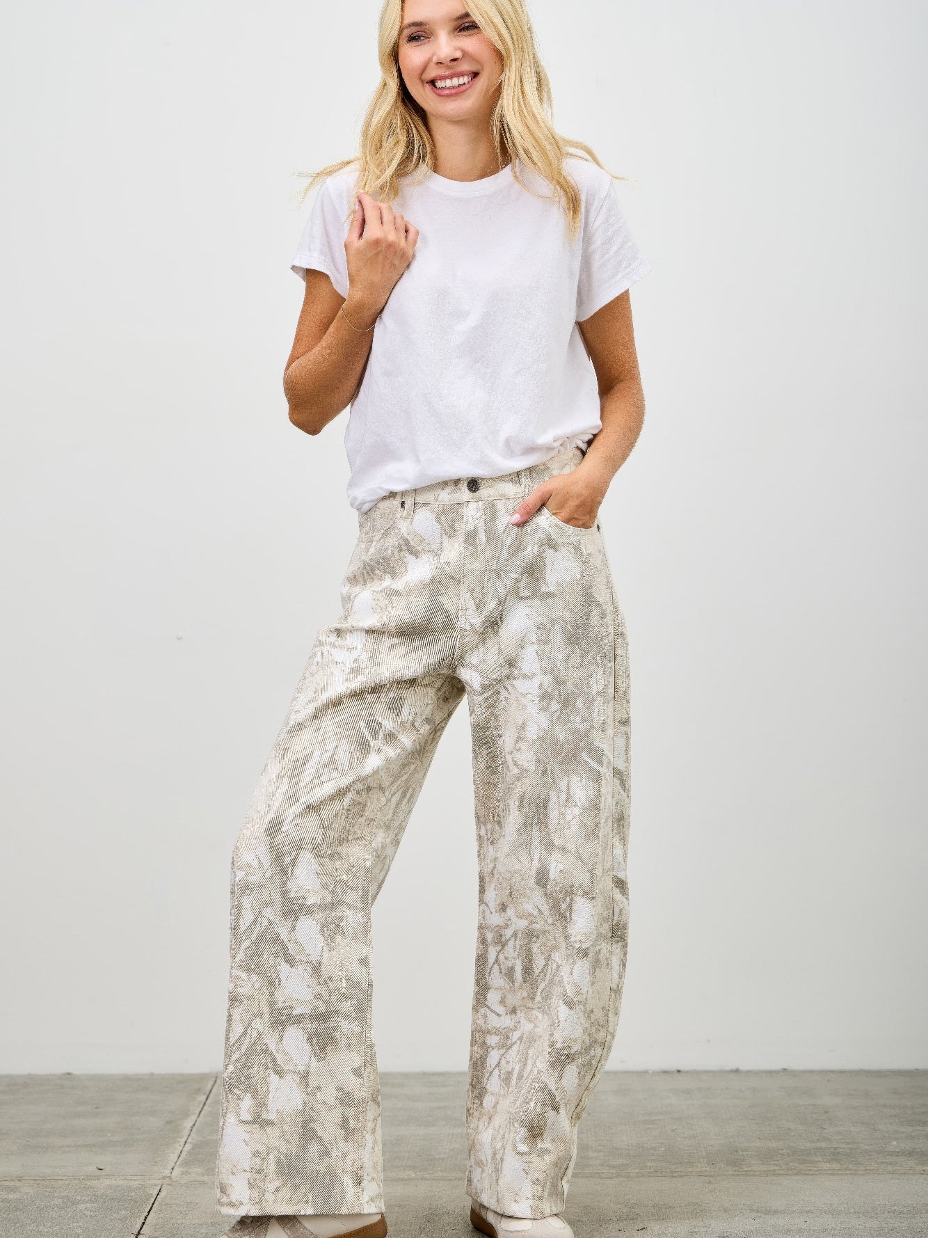 Model wearing High Rise Low Curve Barrel jeans with a printed design and casual white t-shirt, showcasing contemporary style.