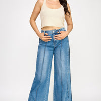 Model wearing High Rise Wide Leg With Tummy Control jeans and a ribbed crop top, showcasing a stylish outfit.
