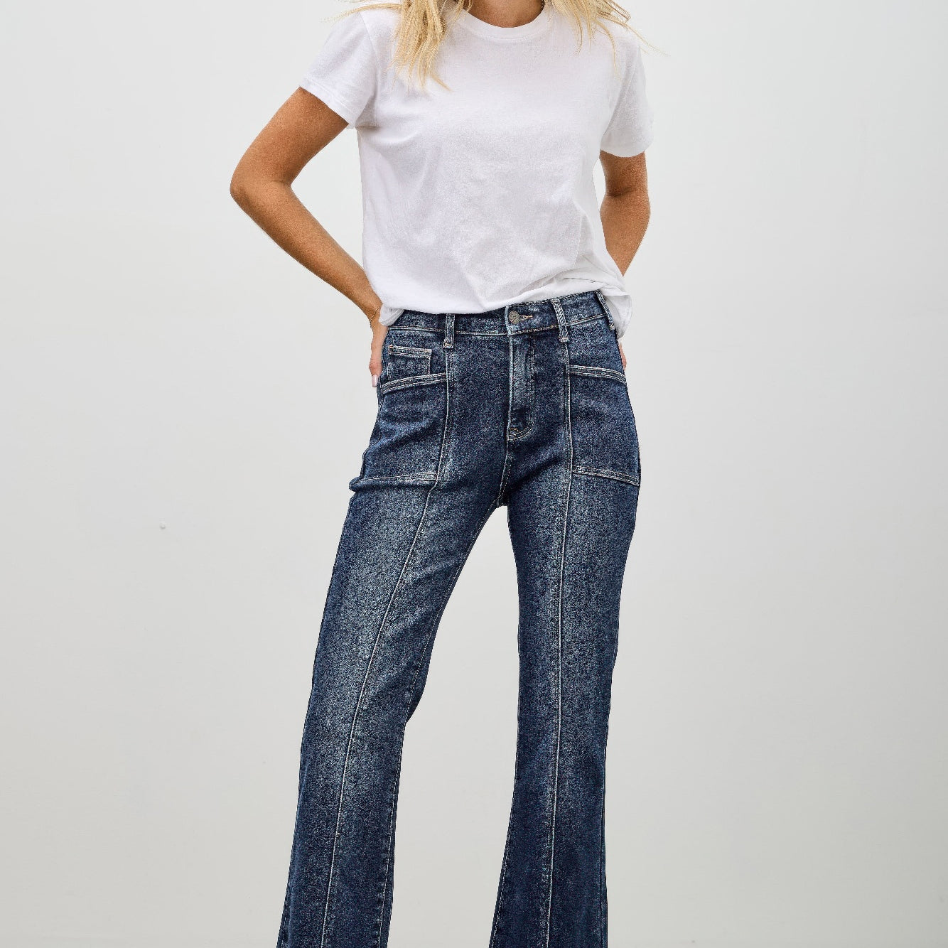 High Rise Boot Cut With Seam Detail, stylish women's jeans with flared hem and seam detailing, model wearing white t-shirt.
