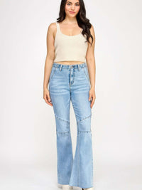 High Rise Flare With Seam Detail showcasing a model wearing light blue jeans with seam accents and a fitted crop top.