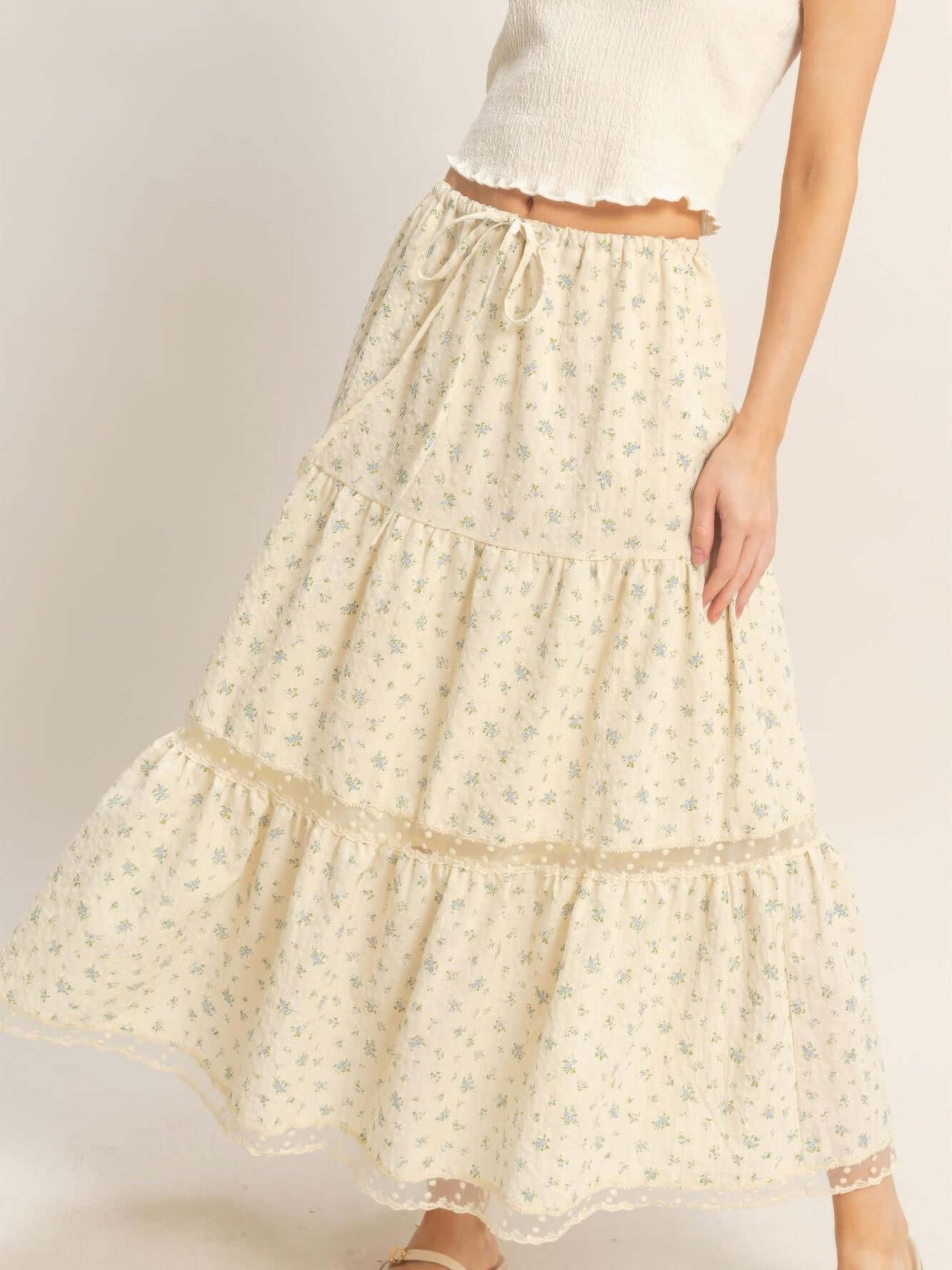 Model wearing a Tiered Lace Trim Skirt with floral pattern and lace detailing, showcasing its flowing silhouette.