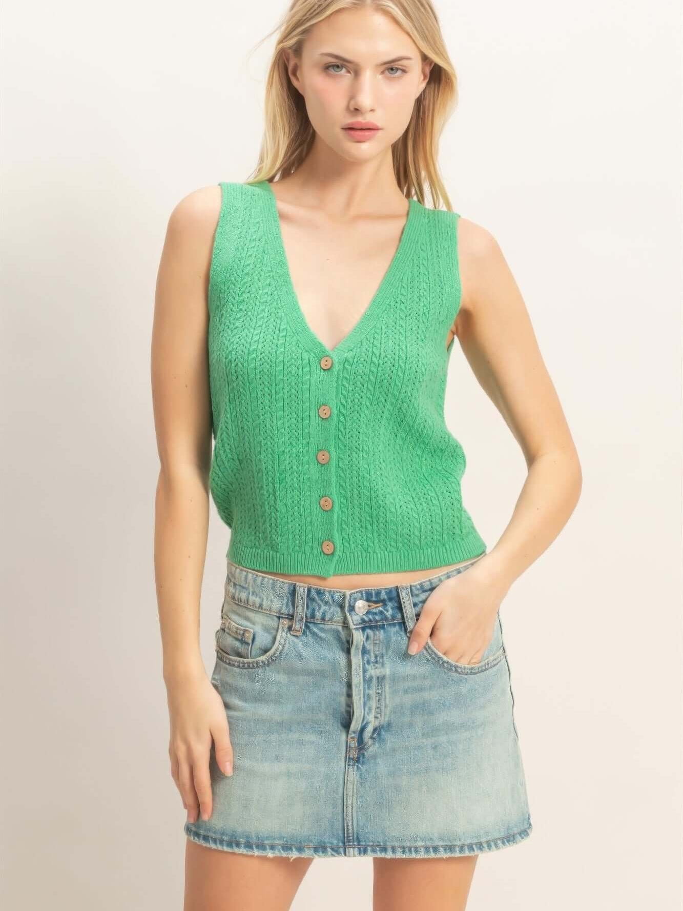 Image of a stylish woman wearing a V-neck Knit Tank Top in green with a button-front design and a denim skirt.