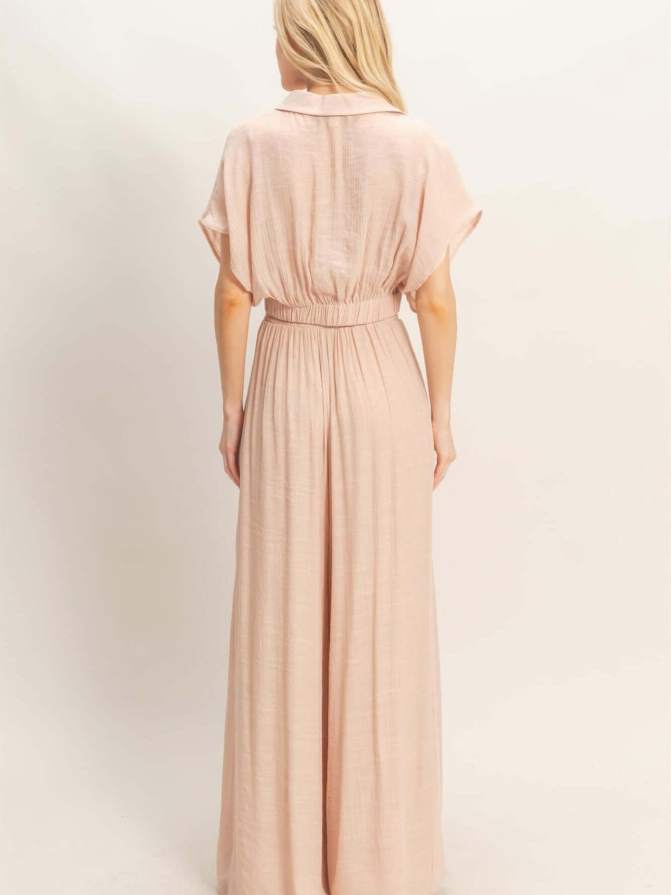 Back view of a woman wearing a Collared Wrap Top & Wide-leg Pants Set in soft pink fabric.