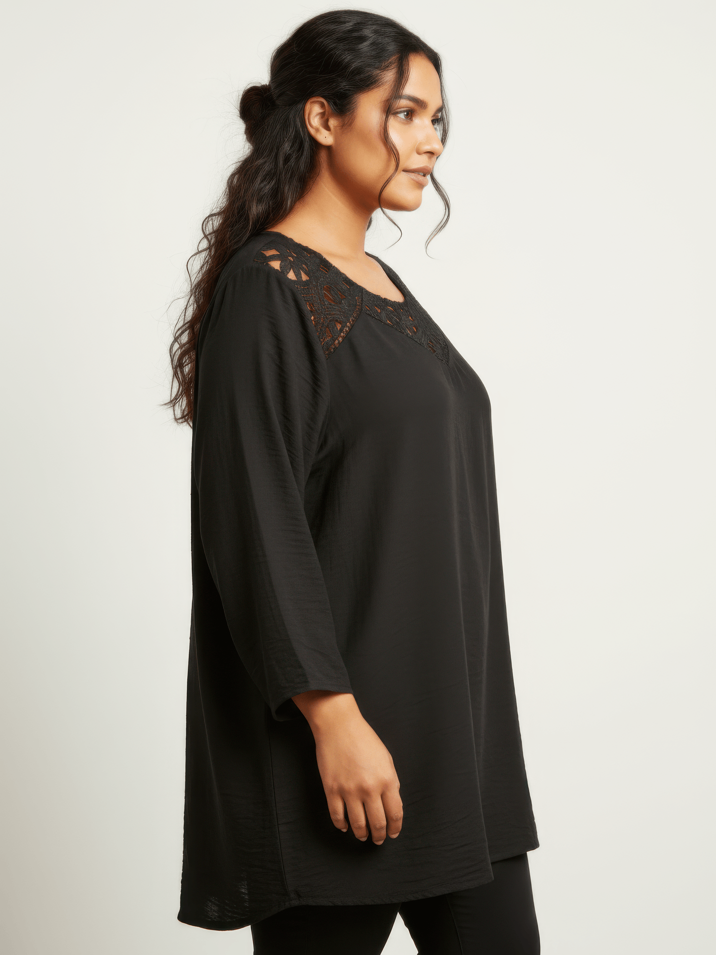The Leila Lace Yoke Bell Sleeve Tunic in black featuring lace detail at neckline and three-quarter bell sleeves.
