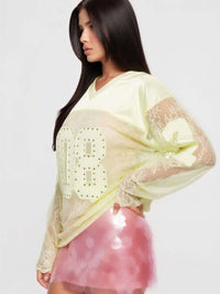 Model wearing 08 Long Sleeve Jersey Top with rhinestones and lace detailing, paired with a pink sequined skirt.