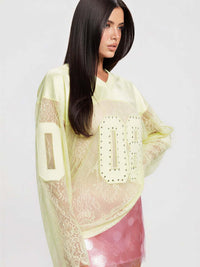 08 Long Sleeve Jersey Top featuring V neckline, lace details, and rhinestone graphic, styled with a vibrant pink skirt.