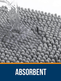 Water being poured on OLANLY's grey absorbent bath rug, showcasing its plush and quick-drying chenille fabric.