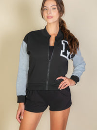 Model wearing a Letter Patched Striped Trim Varsity Jacket with "M" logo, showcasing sporty style and comfort.