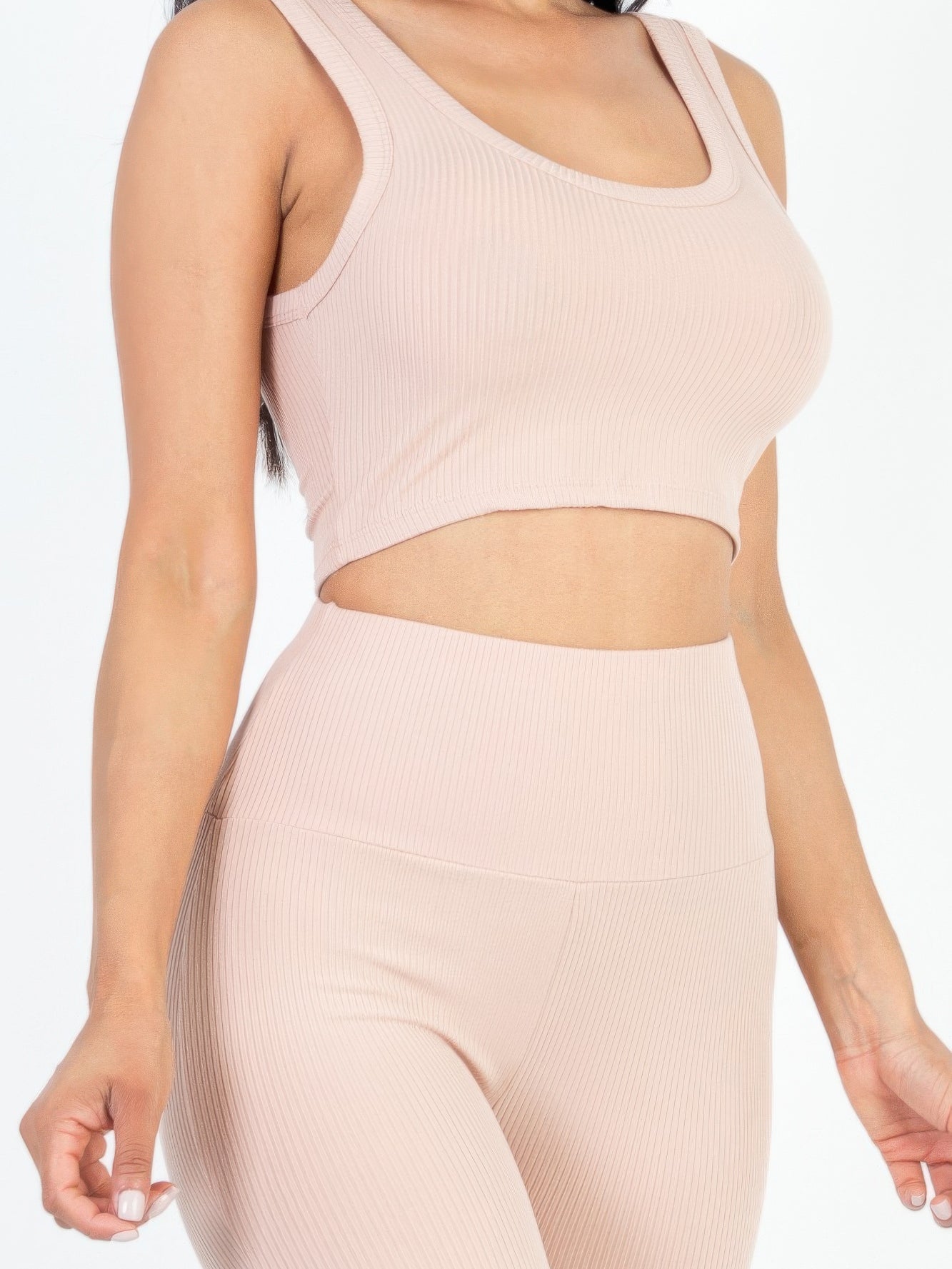 Stylish model showcasing ribbed crop top and leggings set in soft pastel color, ideal for casual or active wear.