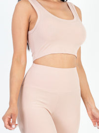 Stylish model showcasing ribbed crop top and leggings set in soft pastel color, ideal for casual or active wear.