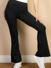 Model wearing high waist side pocket flare leggings in black, showcasing the flattering fit and side pockets.