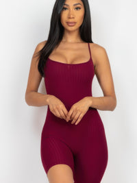 Model wearing ribbed bodycon romper in burgundy, featuring spaghetti straps and a fitted mini biker short design.