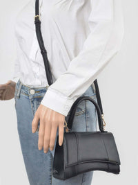 Faux Leather Top Handle Bag displayed on mannequin wearing a white shirt and jeans, showcasing its stylish design.