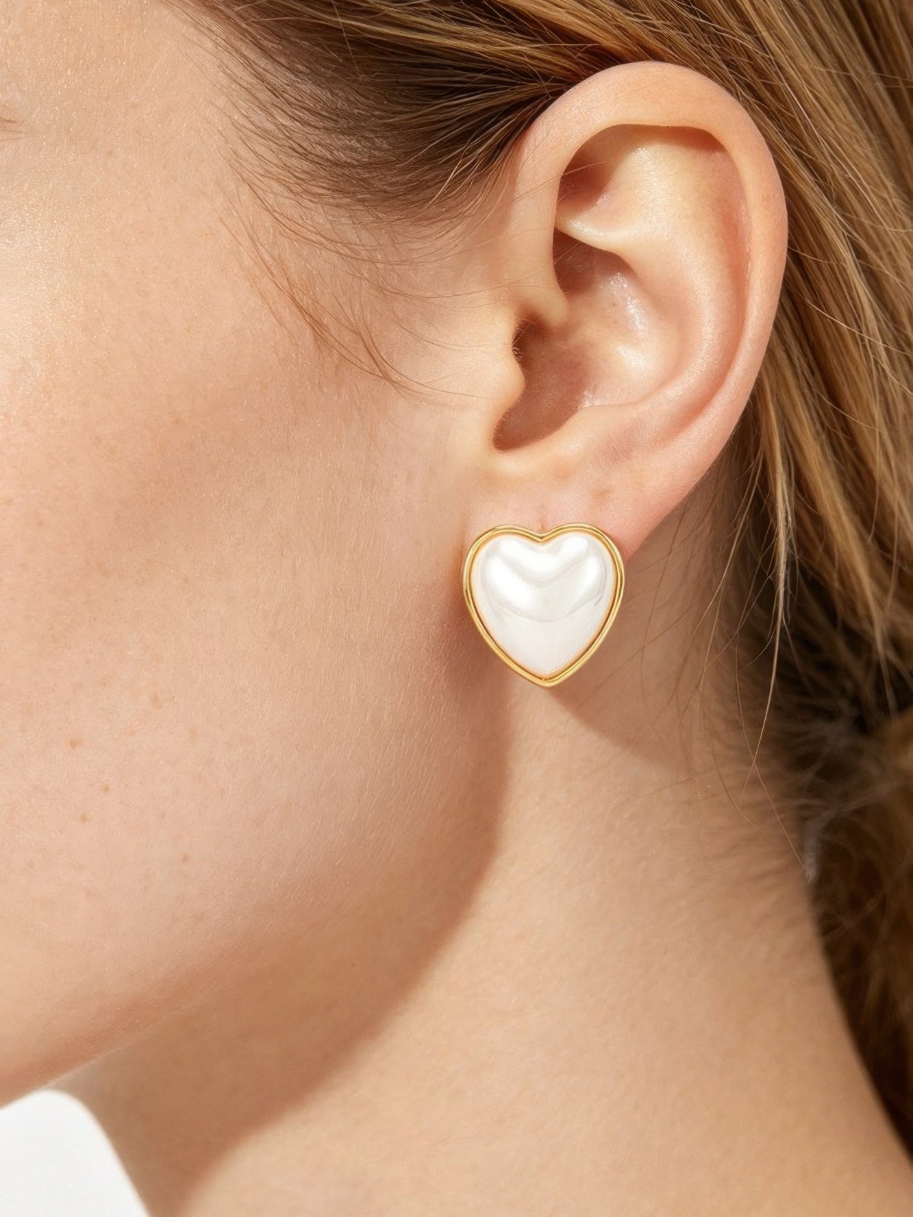 The Amour Pearl Heart Studs – heart-shaped pearl stud earrings with gold metal frame