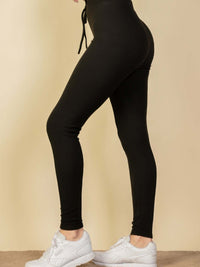 Model showcasing ribbed tie front lounge leggings in black with stylish white sneakers.