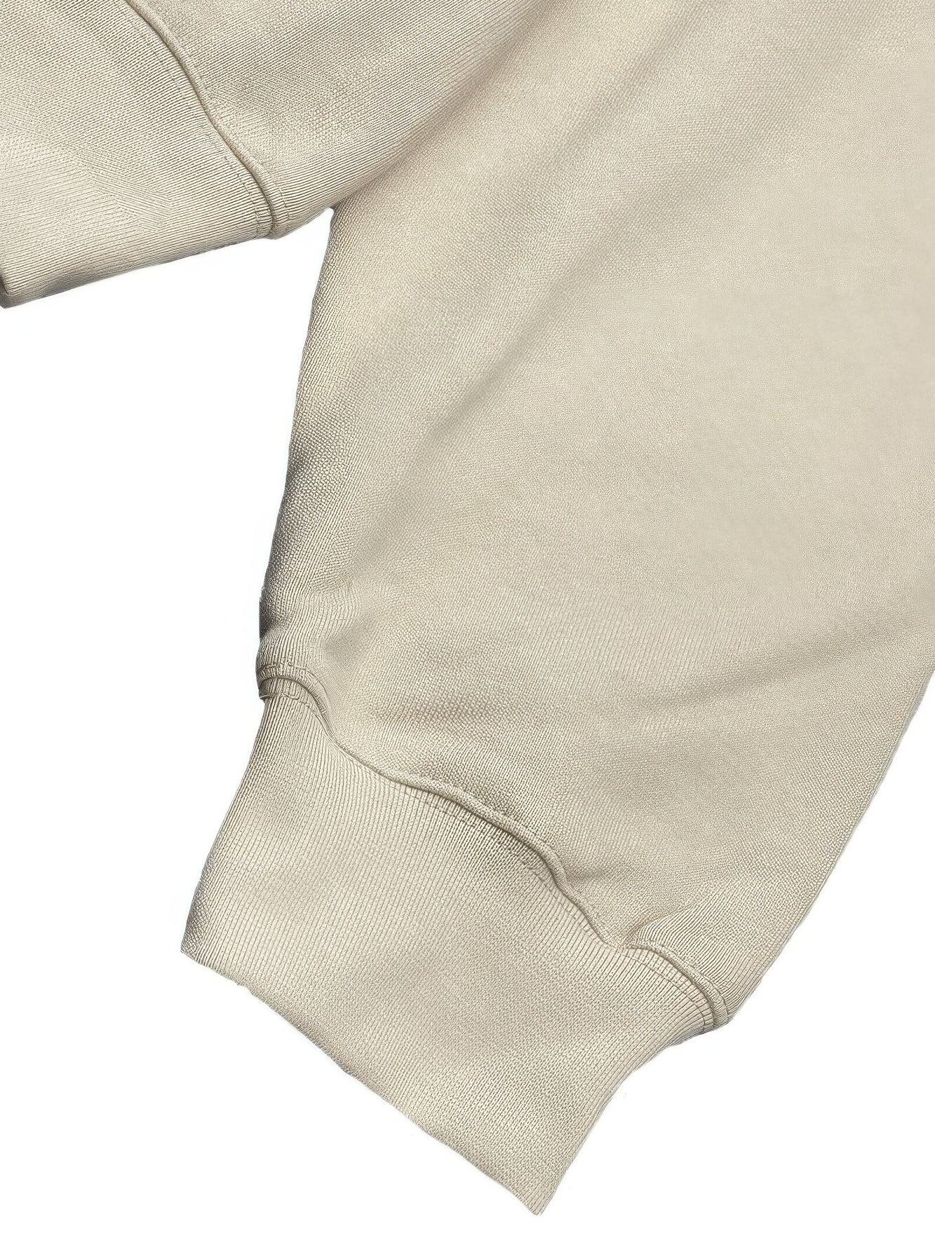 Close-up of the sleeve and cuff of a premium cotton blend hoodie set in a light beige color.