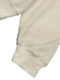 Close-up of the sleeve and cuff of a premium cotton blend hoodie set in a light beige color.