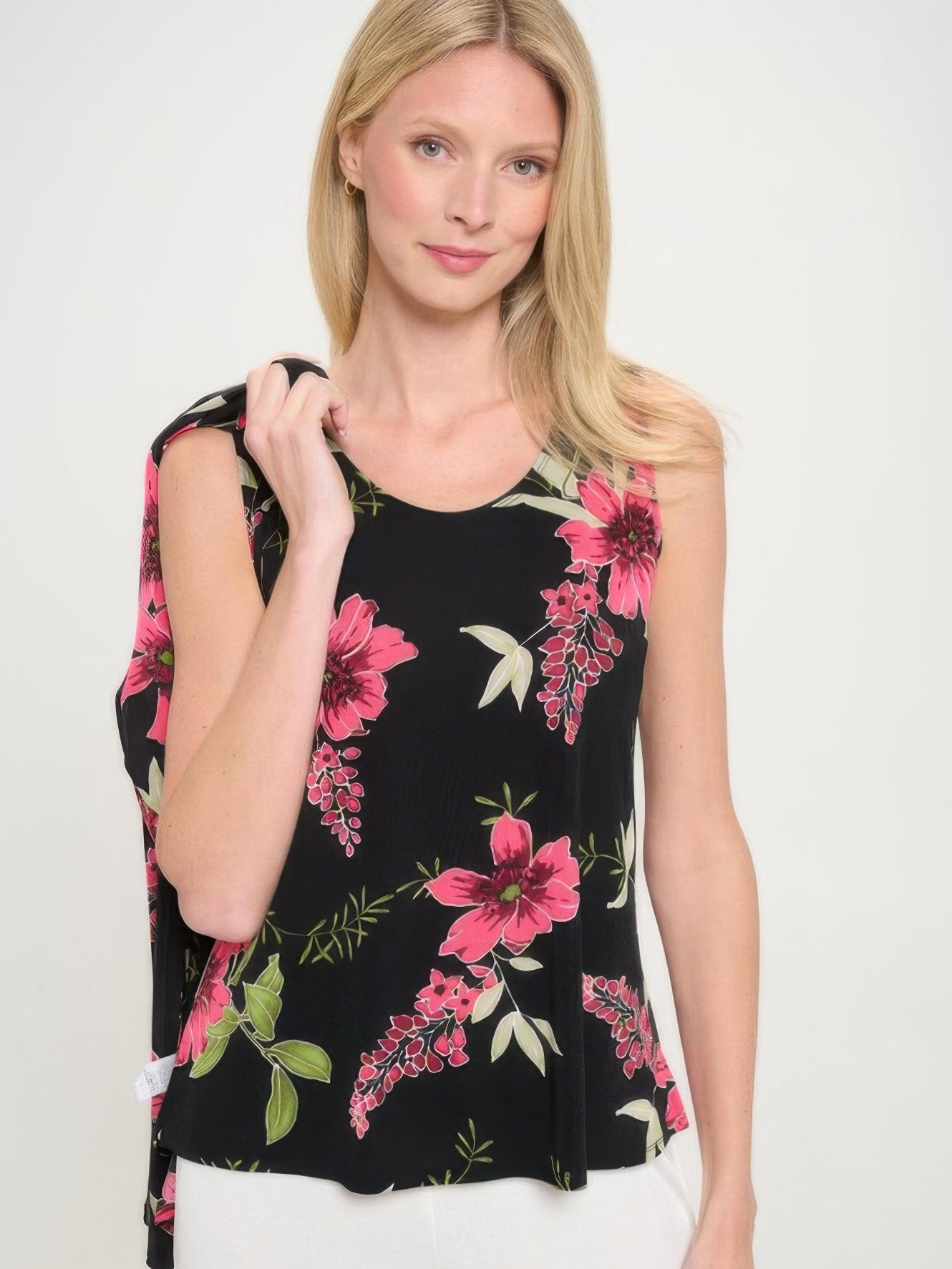 Model wearing BNS print sleeveless tank top styled with floral design on black background.