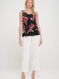 Model wearing the BNS print sleeveless tank top with floral design, paired with white pants.