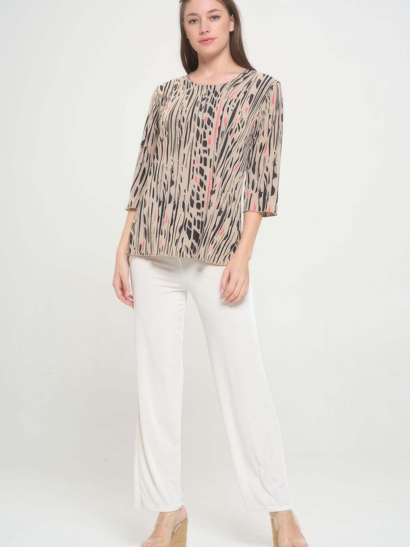 Model showcasing the Print Hit Merrow Top, featuring elegant designs paired with stylish white pants.