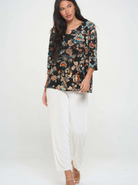 Stylish woman wearing a print quarter sleeve top with floral pattern, paired with white pants.