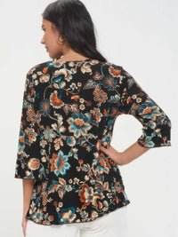 Back view of a woman wearing a floral Print Quarter Sleeve Top in black with colorful accents.
