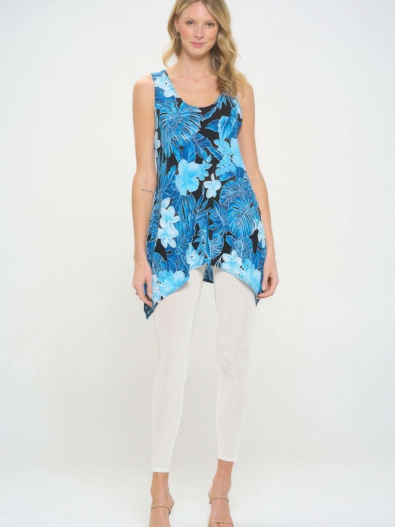 Model wearing a HIT Print Shark Bite Hem Tank Top with a blue floral design paired with white leggings.