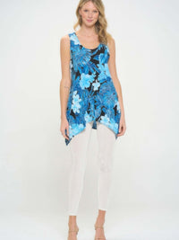 Model wearing a HIT Print Shark Bite Hem Tank Top with a blue floral design paired with white leggings.