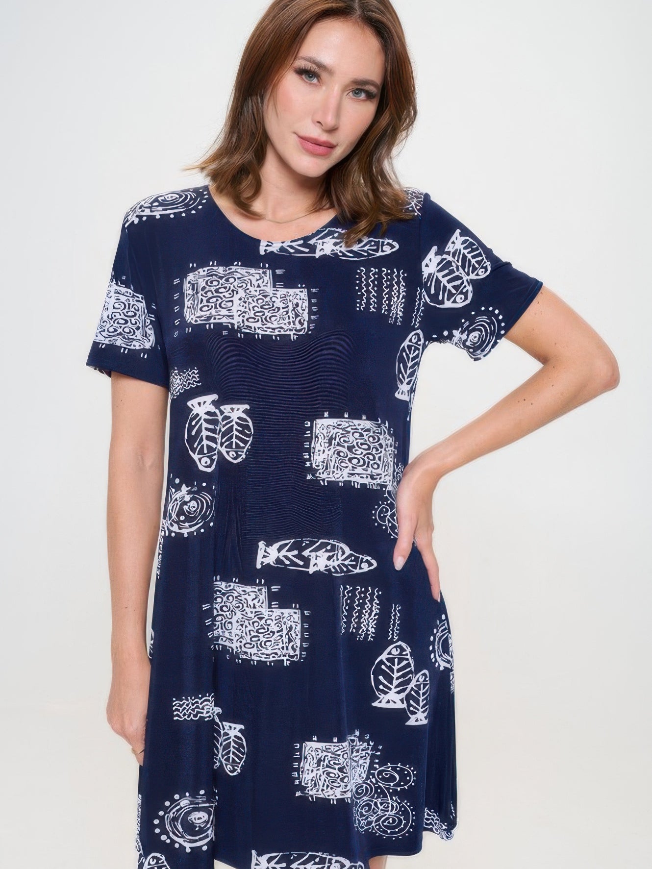 Model wearing a plus size print missy dress with short sleeves and a navy blue pattern.