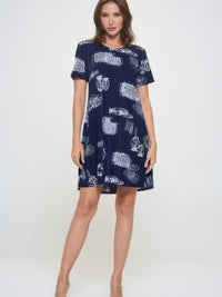 Model wearing a plus size print missy dress with short sleeves and a navy background featuring white patterns.