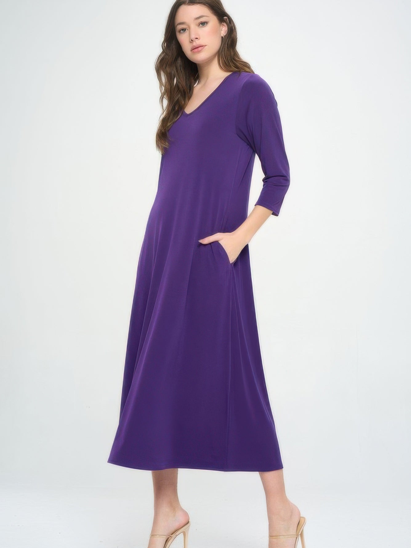 Model wearing a purple V-neck long dress with pockets and quarter sleeves, showcasing a chic and polished look.
