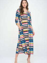 Model wearing a Hit V-neck long dress with pocket, featuring a colorful printed design against a neutral background.