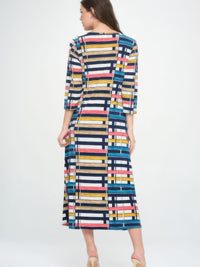 Model showcasing the Hit V-neck long dress with pocket, featuring a colorful geometric print and 3/4 sleeves.