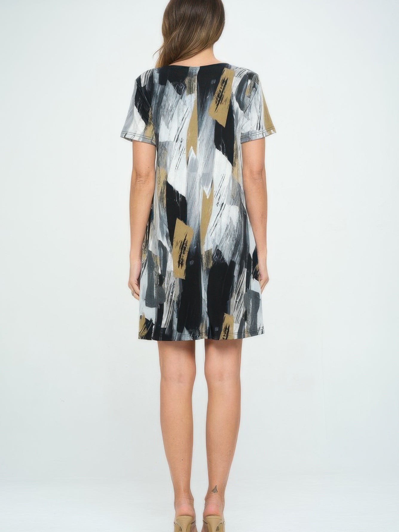 Back view of a woman wearing a Short-Sleeved Knee-Length Dress with a colorful abstract pattern.