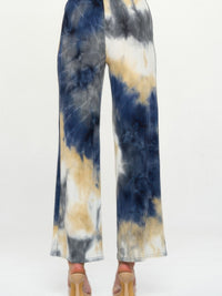 Andante Tie Dye Flared Pants featuring a colorful tie dye print and flared silhouette from the back view.