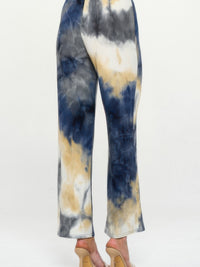 Back view of Andante Tie Dye Flared Pants featuring a colorful tie-dye pattern in navy, white, and beige.