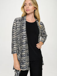 Stylish model wearing ITY Draped Wrap Jacket over a black top, featuring a dynamic printed design.