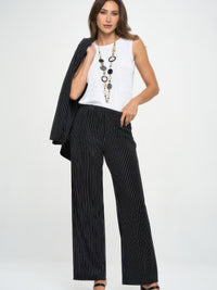 Model wearing Ottoman Flared Pants with stripes, styled with a white tank top and necklace, perfect for a chic outfit.
