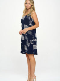 Sleeveless Tank Dress with Round Neckline in navy with decorative print on a model standing side view.