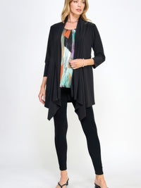 Woman wearing a Draped Quarter Jacket over a colorful top and black leggings, showcasing a stylish layered look.