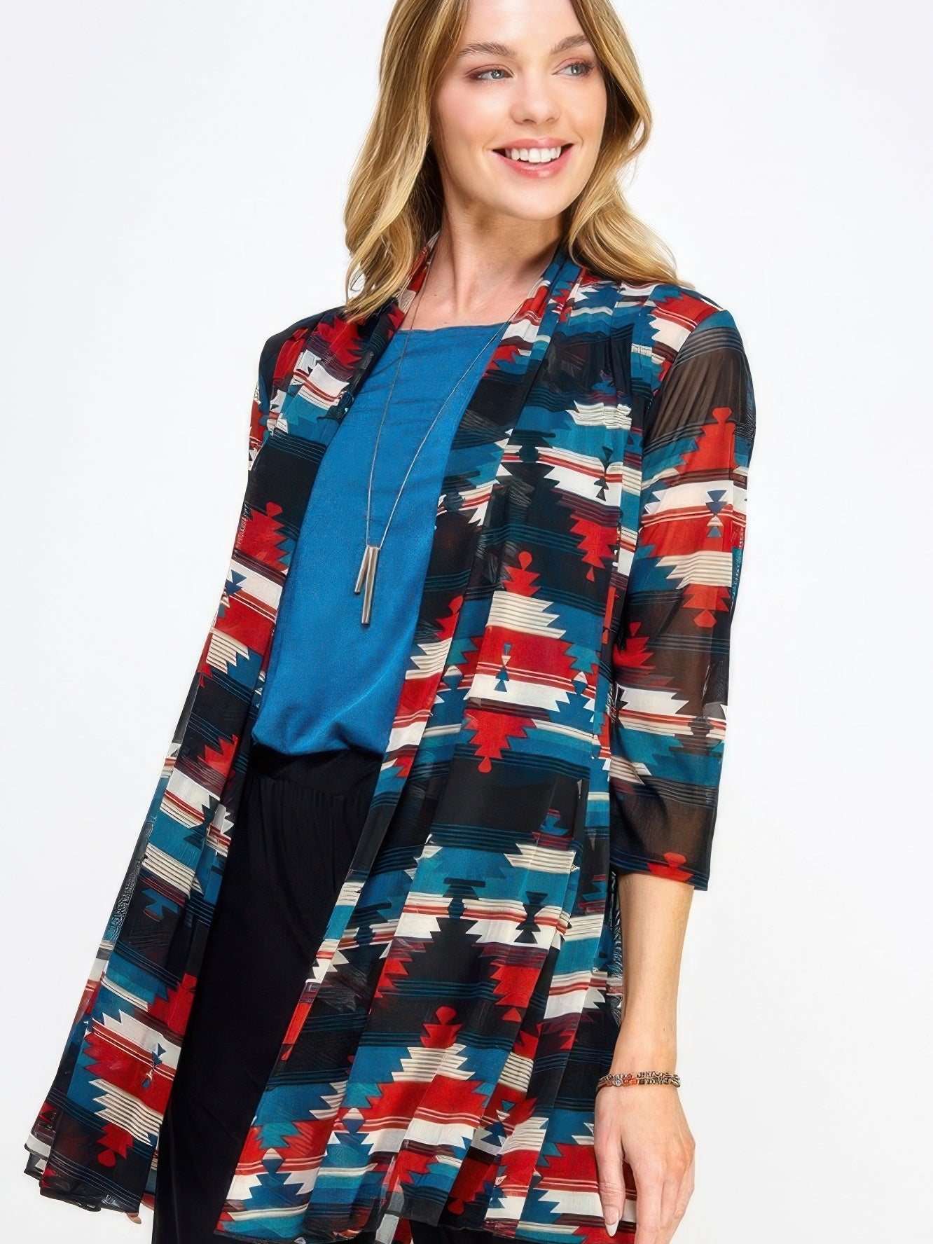 Model wearing the Mr Princess Jacket, a colorful patterned long jacket, styled over a blue top.