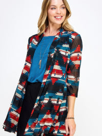 Model wearing the Mr Princess Jacket, a colorful patterned long jacket, styled over a blue top.