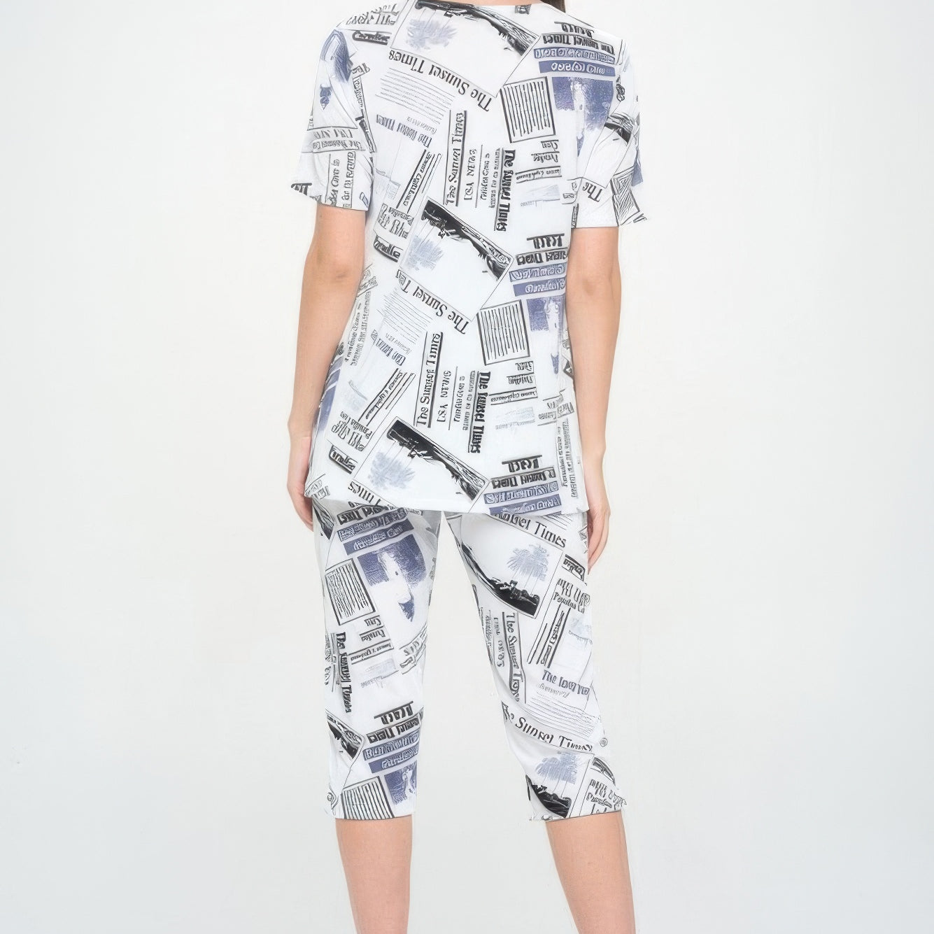 Back view of a model wearing a Short Sleeve Top Capri Pants Set with a newspaper print design.
