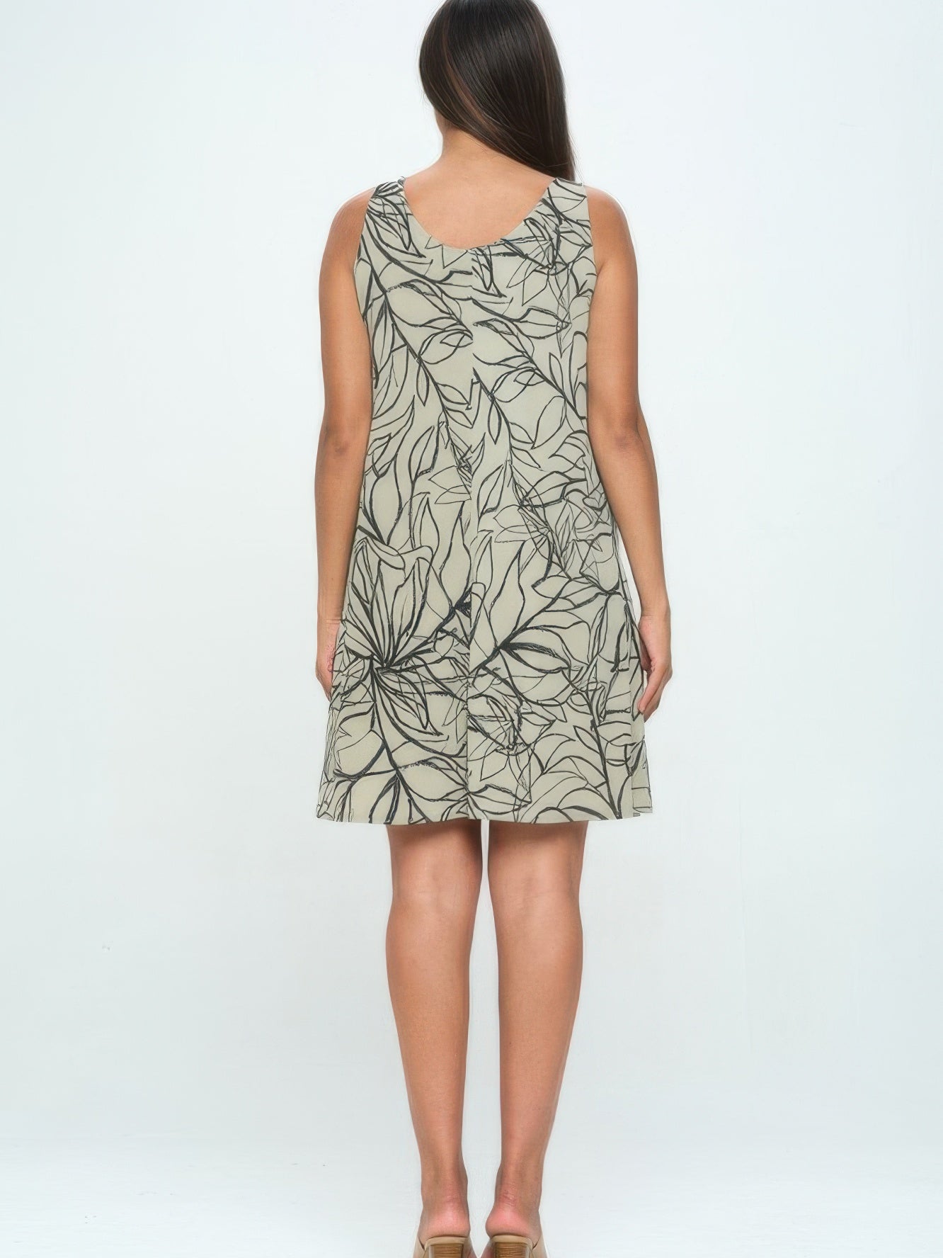 Back view of a woman wearing the Hit Missy Tank Dress featuring a leaf print design.