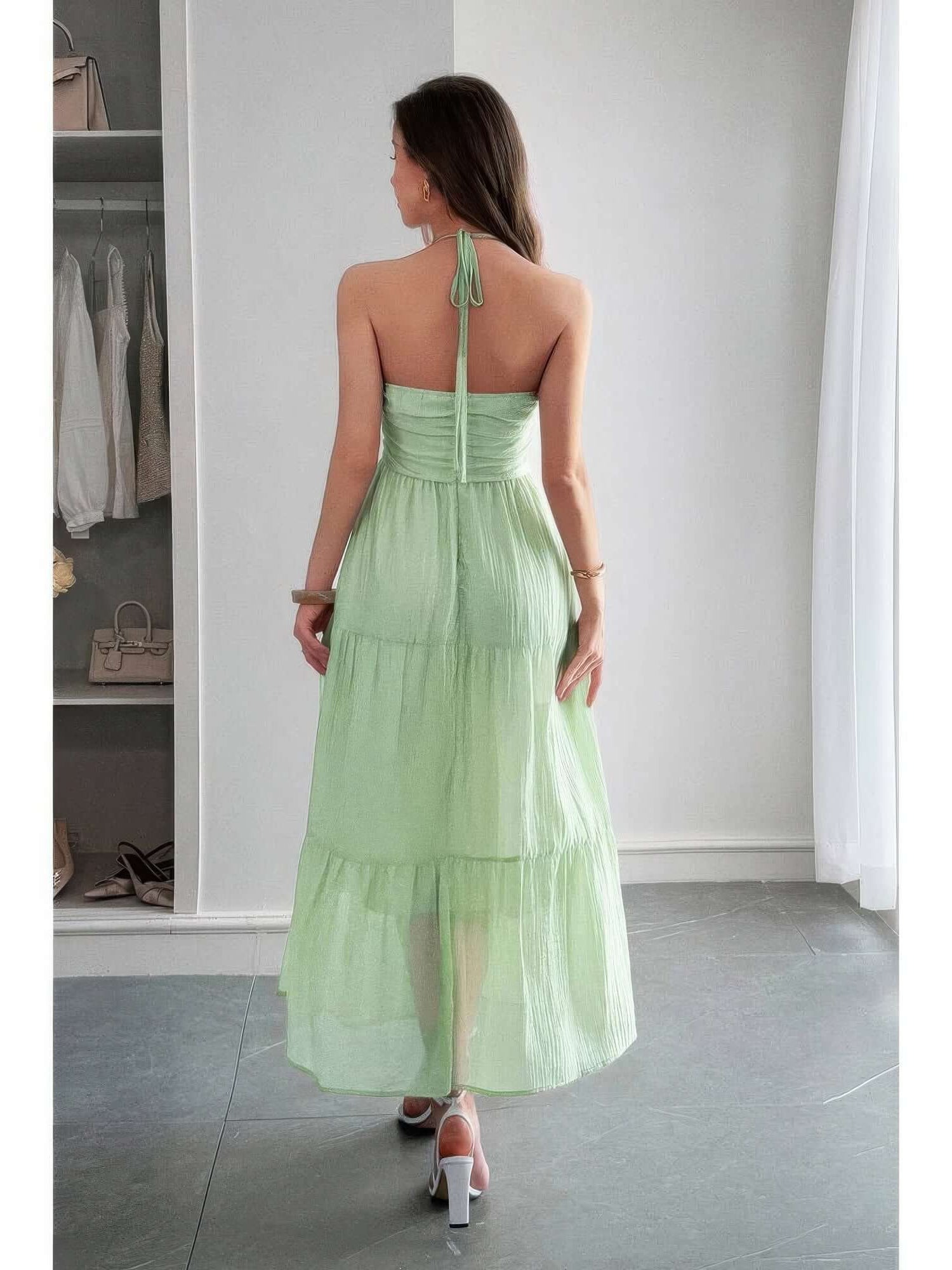 Back view of a model wearing the Solid Halter Muse Tiered Ruffle Long Dress in light green, showcasing the tiered ruffle design.